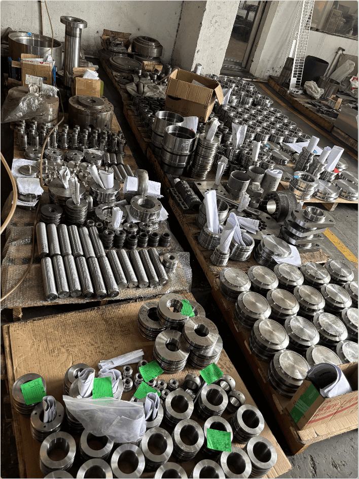 Hydraulic cylinder components including cylinder tube, piston rod, guide bushing, cylinder base, flange, piston and clevis — precision machined stainless steel and carbon steel parts by JW Hydraulic.